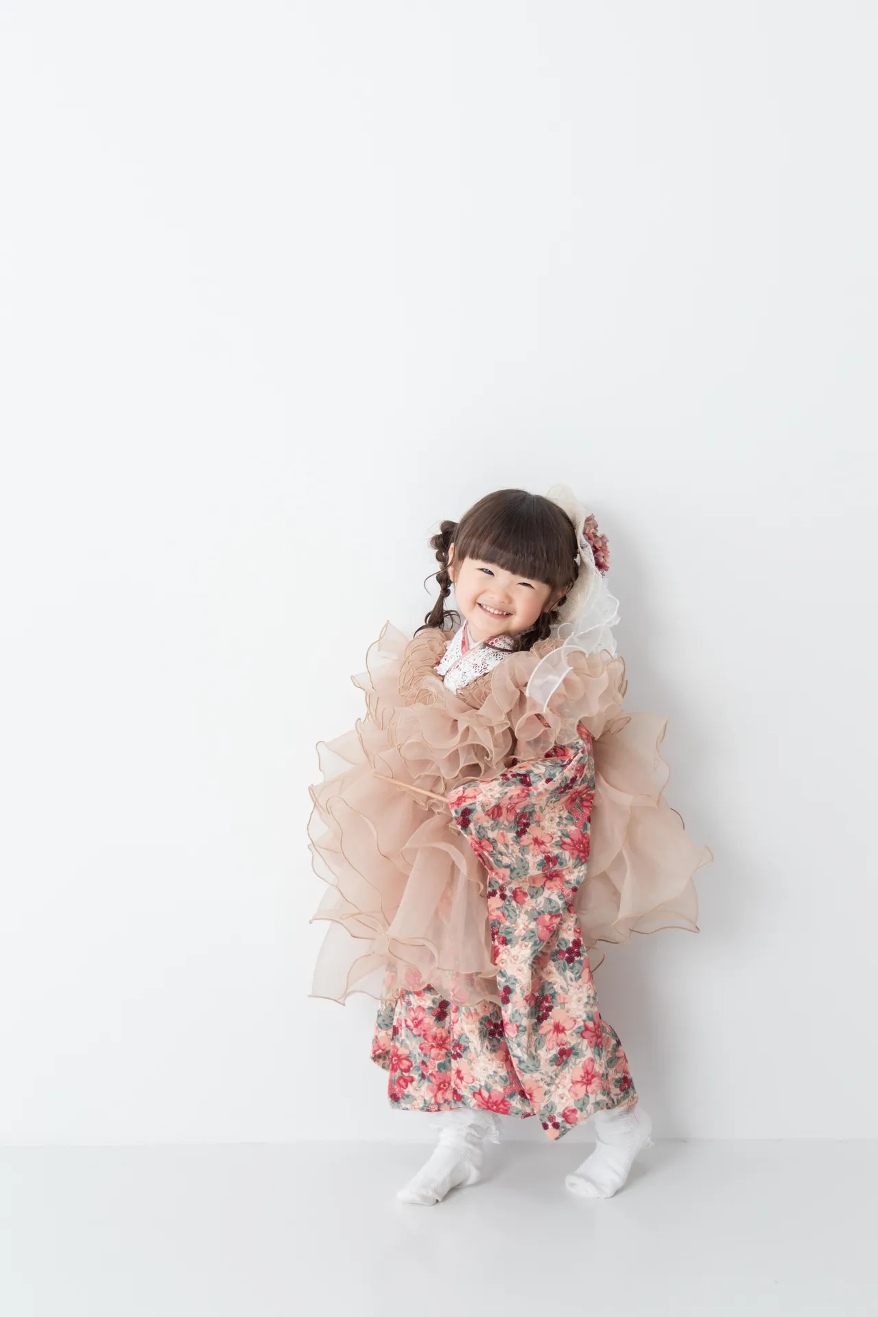 白い背景の前で、フリルの衣装の女の子が立っている写真